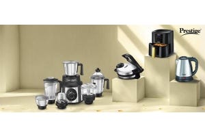 Prestige kitchen appliances including a mixer grinder, air fryer, electric kettle, and more, displayed on pedestals in a modern setting showcasing essential kitchen gadgets.
