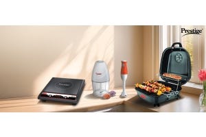 Prestige kitchen appliances including a black induction cooktop, chopper, orange hand blender, and portable charcoal grill 