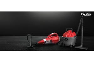 Two red Prestige vacuum cleaners, including a handheld and a wet-dry model, placed on a black surface for efficient home cleaning.